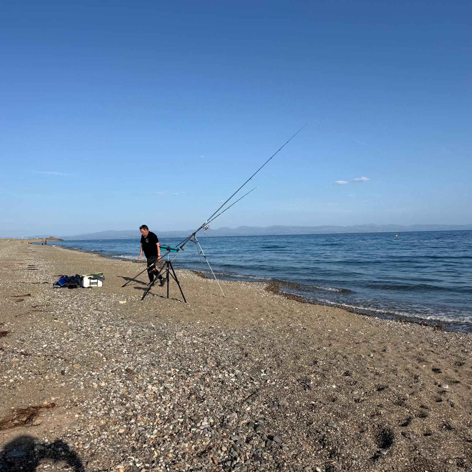 A family fishing together from a sandy beach in North Wales