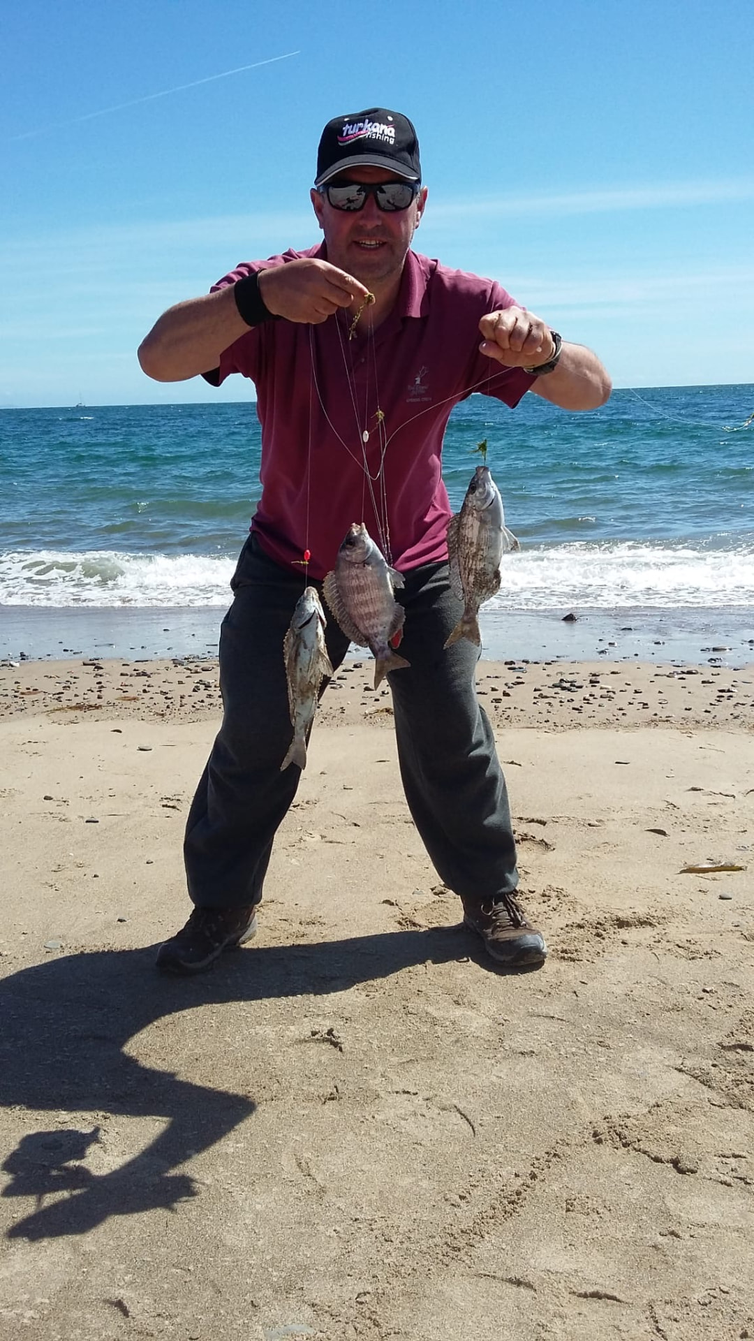Three fish on one rig — a good drop on a summer beach